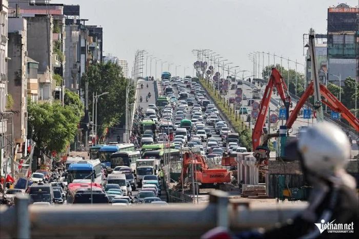 Các phương tiện xếp hàng dài qua công trường thi công hầm chui Cổ Linh. (Ảnh: Đình Hiếu)