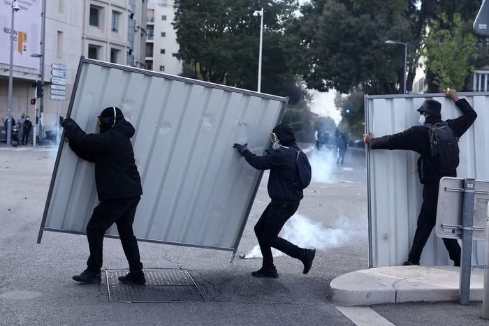 Người biểu tình dùng tấm tôn để che chắn ở Marseille. (Ảnh: Reuters)