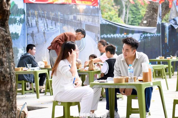 Hình ảnh thực khách quây quần bên những chiếc bàn nhỏ, thưởng thức món ăn và trao đổi cùng bạn bè tạo nên không khí gần gũi, khác với nhịp độ nhanh của các hoạt động trải nghiệm công nghệ tại lễ hội.
