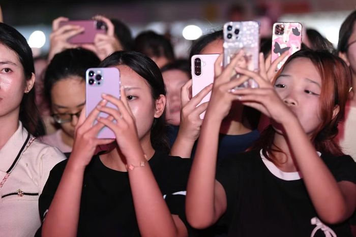 Hàng nghìn chiếc điện thoại được giơ lên để ghi lại khoảnh khắc đáng nhớ.