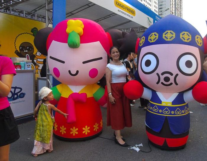 Người dân và các em nhỏ thích thú check-in cùng các mô hình mascot trang phục truyền thống Hàn Quốc tại lễ hội. (Ảnh: Thảo Tâm)