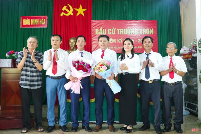 Các đại biểu tặng hoa chúc mừng trưởng thôn sau khi trúng cử.