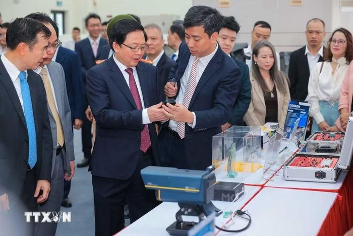 Phó Thủ tướng Hồ Quốc Dũng cùng các đại biểu tham quan các sản phẩm tại Phòng thí nghiệm đóng gói và đo kiểm chip bán dẫn. (Ảnh: Hoàng Hiếu/TTXVN)