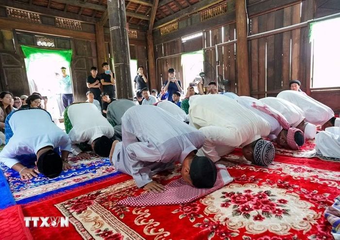 Những người đàn ông Chăm Islam mặc trang phục truyền thống, cùng nhau đến thánh đường thực hiện nghi lễ cầu nguyện. (Ảnh: Khánh Hòa/TTXVN)