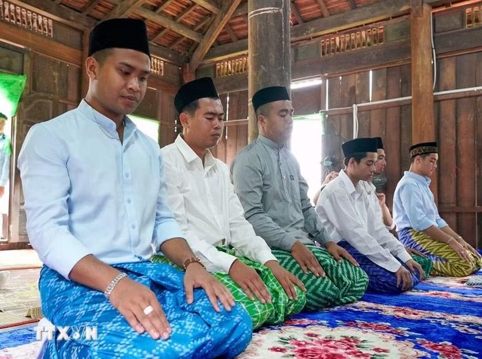 Những người đàn ông Chăm Islam mặc trang phục truyền thống, cùng nhau đến thánh đường thực hiện nghi lễ cầu nguyện. (Ảnh: Khánh Hòa/TTXVN)