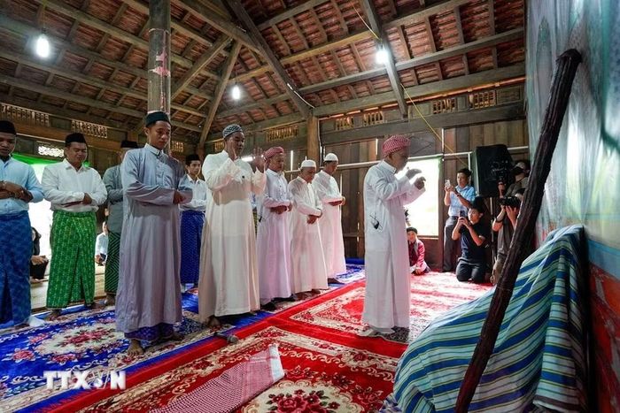 Những người đàn ông Chăm Islam mặc trang phục truyền thống, cùng nhau đến thánh đường thực hiện nghi lễ cầu nguyện. (Ảnh: Khánh Hòa/TTXVN)