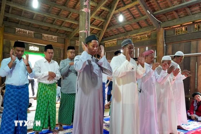Những người đàn ông Chăm Islam mặc trang phục truyền thống, cùng nhau đến thánh đường thực hiện nghi lễ cầu nguyện. (Ảnh: Khánh Hòa/TTXVN)