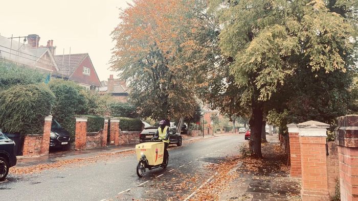 Người giao hàng đạp xe thùng chạy điện qua con phố ướt mưa. Nhịp mưu sinh của một London đang “xanh hóa” giao thông.