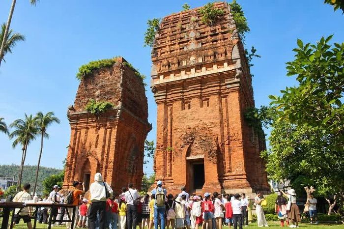 Các em học sinh, sinh viên giao lưu với nghệ sĩ tuồng dưới chân tháp cổ.