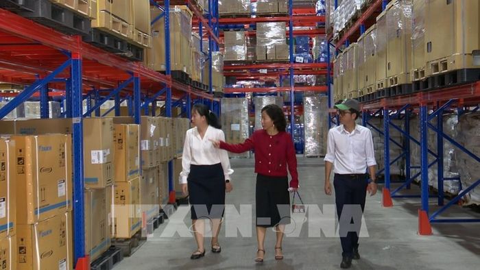 Bà Nguyễn Thị Thảo Ngân (mặc áo đỏ), Phó Tổng Giám đốc Công ty Cổ phần Anpha-AG, tại khu công nghiệp Long Hậu, tỉnh Tây Ninh đang giới thiệu hệ thống lưu trữ hàng hóa trong kho. Ảnh: Thanh Bình –TTXVN