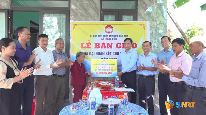 Đại diện Ủy ban MTTQ xã Thăng Điền bàn giao nhà đại đoàn kết cho bà Hồ Thị Nhượng. Ảnh: GIANG BIÊN