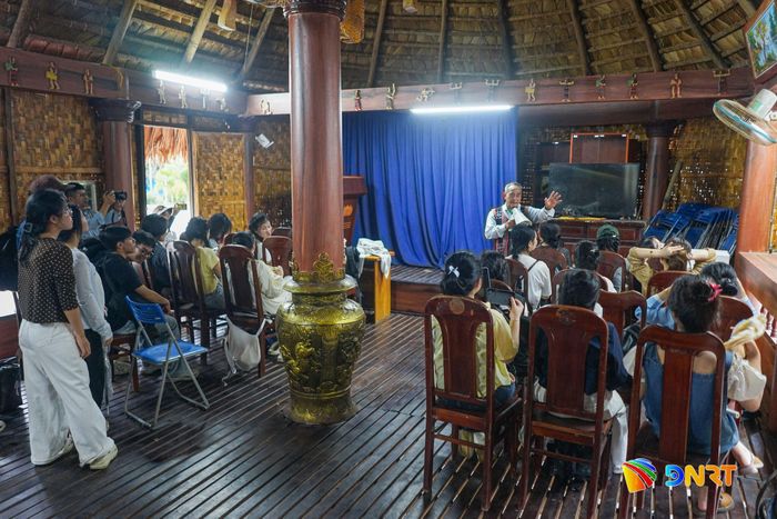 Dưới mái Gươl, sinh viên nghe người dân phường Hải Vân chia sẻ về cuộc sống cộng đồng. Ảnh: XUÂN SƠN