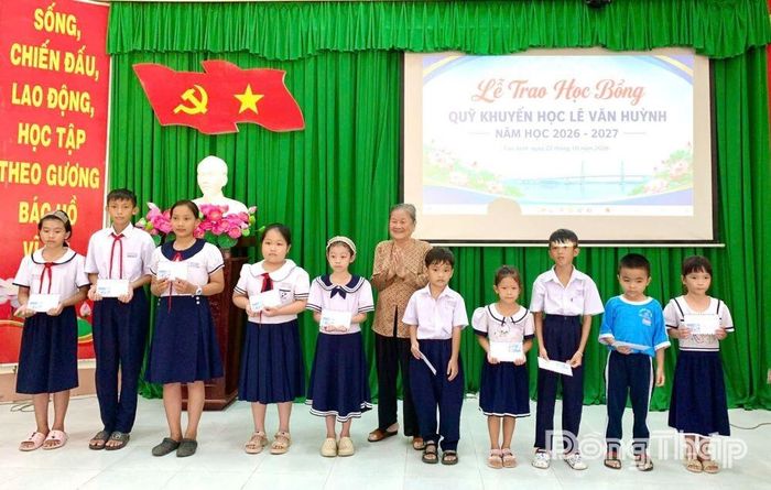 Đại diện Ban Quản lý Quỹ Khuyến học Lê Văn Huỳnh trao học bổng cho học sinh.