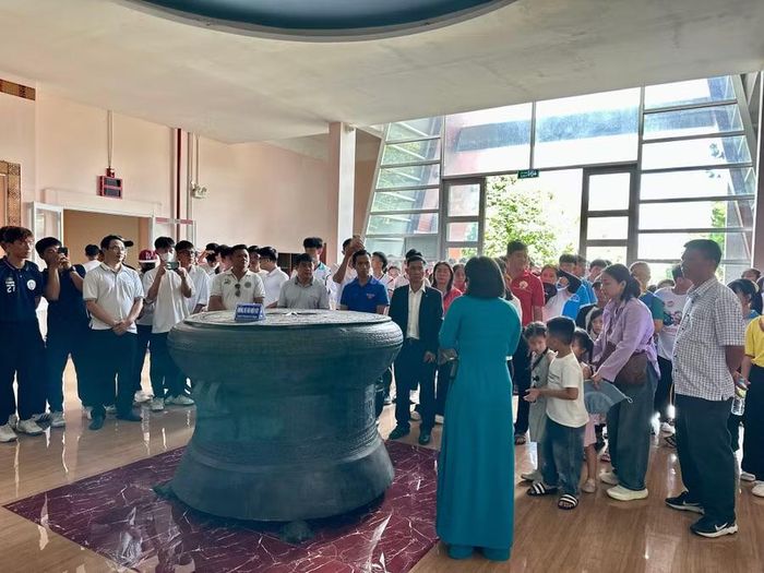  Đoàn nghe giới thiệu về Trống đồng Ngọc Lũ (hiện vật phục chế). Ảnh: Hà Duy 