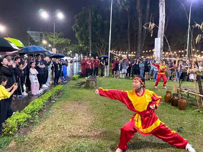 Khán giả đội mưa thưởng thức phần trình diễn võ thuật của các võ sinh đến từ Trung tâm Võ thuật cổ truyền Bình Định. Ảnh: Lam Nguyên