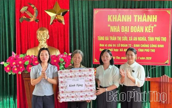 Đại diện Ủy ban Mặt trận Tổ quốc và các tổ chức, đoàn thể xã An Nghĩa tặng quà chúc mừng gia đình bà Trần Thị Sửu, thôn Phú Bình trong ngày khánh thành nhà mới.