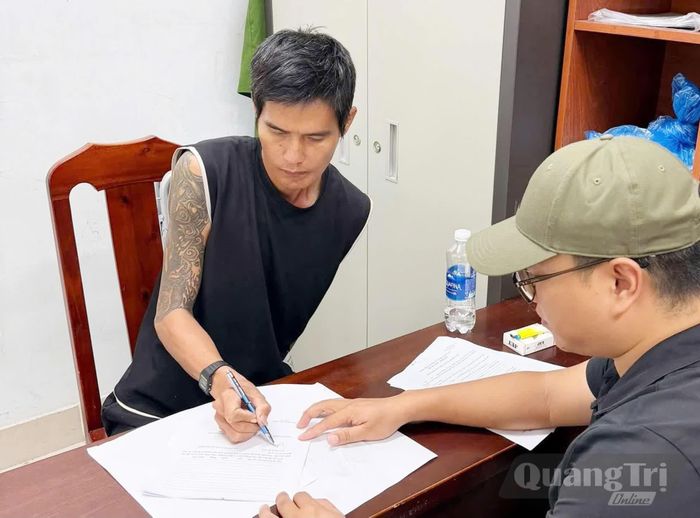 Đối tượng bị truy nã Lê Minh Hải ký vào biên bản bắt giữ - Ảnh: C.A