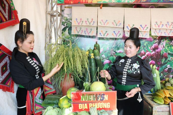 Bà con dân tộc Thái giới thiệu các mặt hàng nông sản đặc sản của địa phương tại không gian trưng bày.