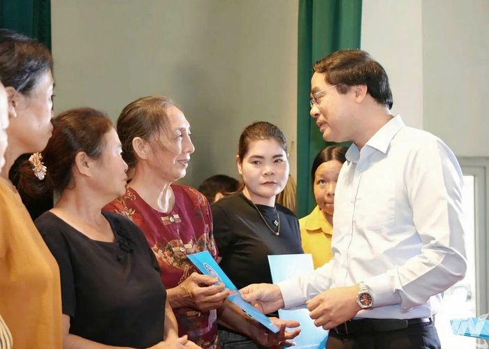 Đồng chí Bí thư Tỉnh ủy Trịnh Xuân Trường trao thẻ bảo hiểm y tế tặng người dân.