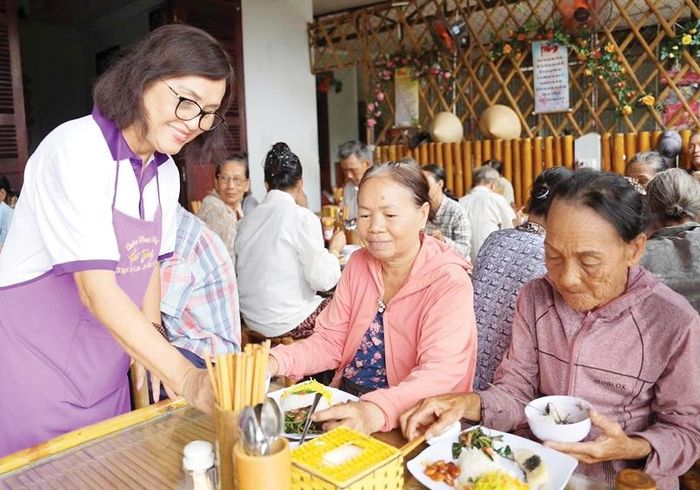 Tình nguyện viên quán chay Huế Thương phục vụ cơm cho những người đến quán dùng bữa.