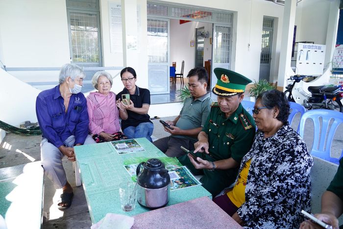 Cán bộ vận động quần chúng đồn Biên phòng Vĩnh Nguơn, phối hợp với cán bộ phường Vĩnh Tế, hướng dẫn người dân truy cập vào hòm thư điện tử tố giác tội phạm. Ảnh: Tiến Vinh