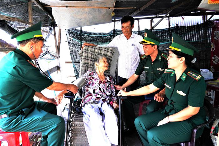Cán bộ đồn Biên phòng Vĩnh Nguơn, thăm, khám bệnh, tặng quà cho người cao tuổi trên địa bàn. Ảnh: Tiến Vinh