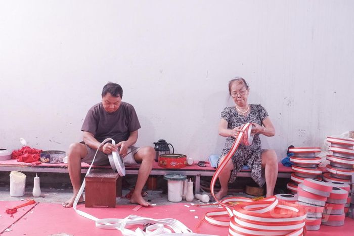 Những người thợ tại thôn Giáp Nhất thực hiện công đoạn quấn và tạo nếp khăn xếp bằng tay.