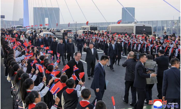Nhà lãnh đạo Triều Tiên Kim Jong Un đi bộ qua cầu hữu nghị Trung - Triều mới khánh thành bắc qua sông Áp Lục - Ảnh: KCNA