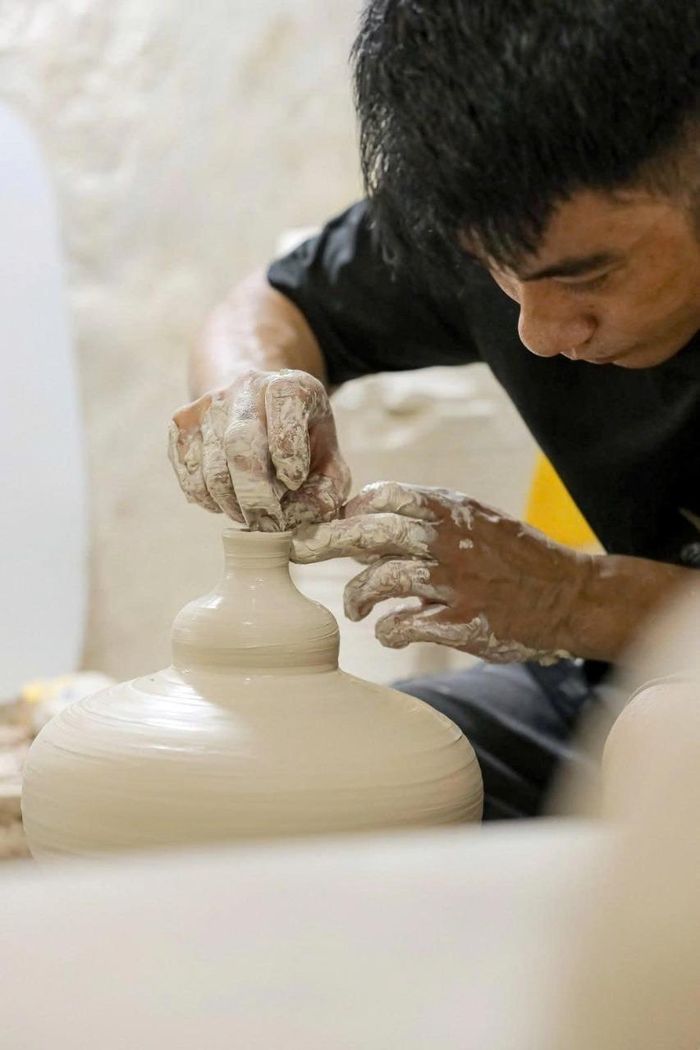 Người thợ tỉ mỉ tạo hình sản phẩm trên bàn xoay, tiếp nối kỹ thuật thủ công truyền thống của nghề gốm. (Ảnh: Phí Đức Toàn)