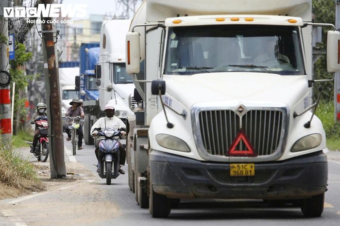 Xe container, xe tải nặng và xe cá nhân chen chúc trên đường, tiềm ẩn nguy cơ tai nạn. (Ảnh: Lương Ý)