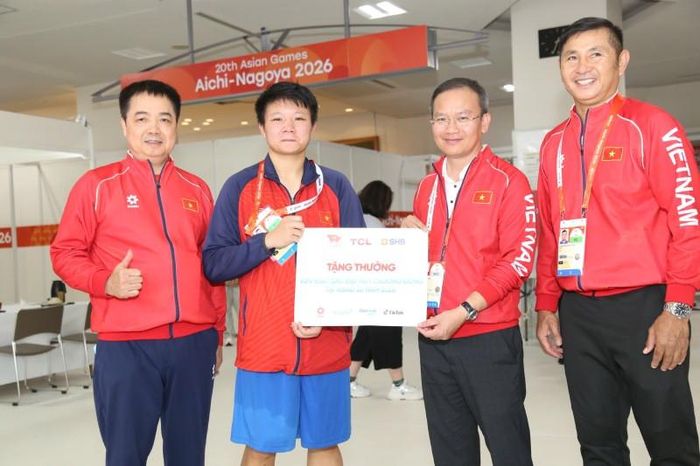 Võ sĩ Lưu Diễm Quỳnh (thứ hai từ trái sang) nhận thưởng nóng từ lãnh đạo Đoàn thể thao Việt Nam tại ASIAD 20. Ảnh: Bùi Lượng