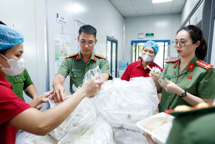 Trung tá Nguyễn Minh Hiếu - Phó trưởng CAP Hoàng Mai sắp xếp các suất ăn trước khi chuyển cho đồng đội mang vào phòng bệnh
