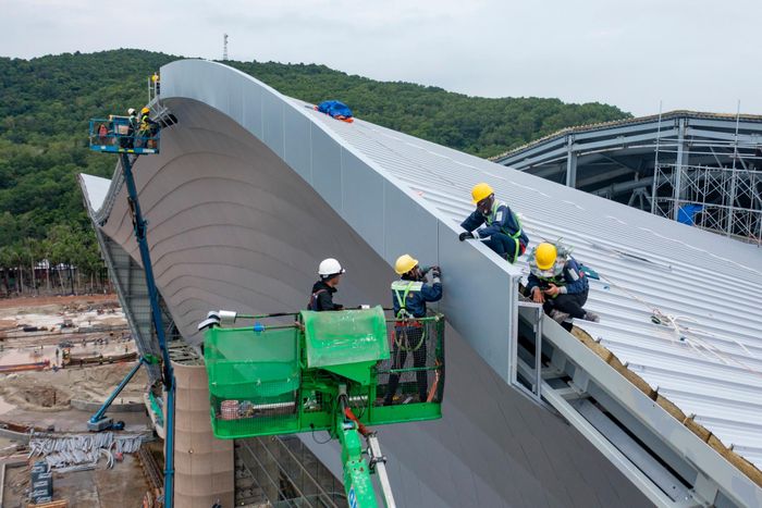 Công nhân làm việc xuyên nắng mưa, chạy đua với thời gian để bảo đảm tiến độ các công trình phục vụ APEC 2027. Ảnh: Quỳnh Danh.