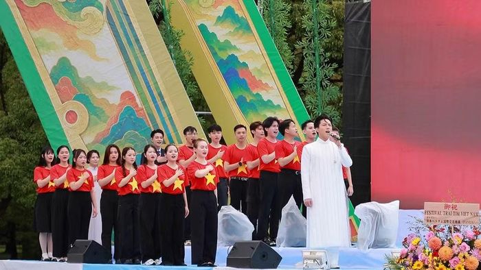 Ca sĩ Anh Tú cùng 34 kiều bào hát Quốc ca. (Ảnh: Ban tổ chức)