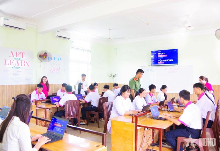  Công an tỉnh Khánh Hòa và các giáo viên hướng dẫn học sinh tìm hiểu kiến thức về an toàn trên không gian mạng trên máy tính.