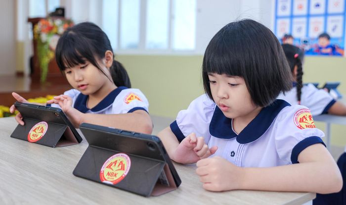  Các em học sinh Trường Tiểu học Nguyễn Bỉnh Khiêm hứng thú với trò chơi tương tác trong môn học có ứng dụng AI. Ảnh: HOÀNG TRIỀU 