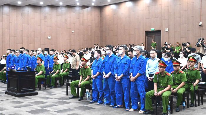  Các bị cáo trong vụ án đứng nghe phổ biến phiên xét xử. Ảnh: GIA KHÁNH 