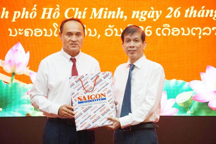  Tổng Biên tập Báo SGGP Nguyễn Khắc Văn trao quà lưu niệm đến đồng chí Somsack Sakounkham, trưởng đoàn công tác. Ảnh: VIỆT NGA 