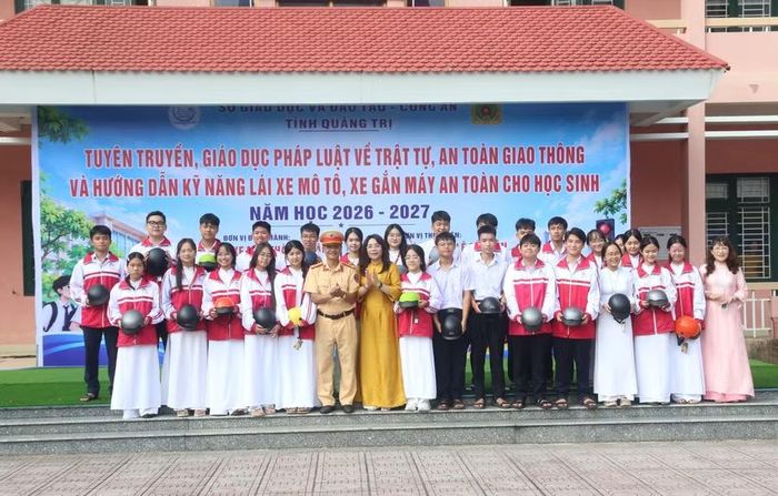 Đại diện lãnh đạo Sở GD&ĐT, Phòng CSGT Công an tỉnh và Trường THPT chuyên Lê Quý Đôn tặng mũ bảo hiểm cho học sinh.