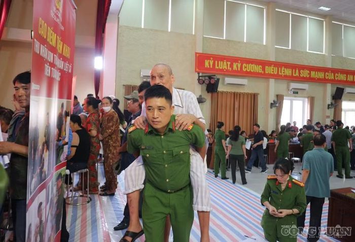 Không chỉ hỗ trợ về mặt thủ tục, cán bộ, chiến sĩ còn quan tâm đến việc di chuyển của những người sức khỏe yếu. Ảnh: Kim Long