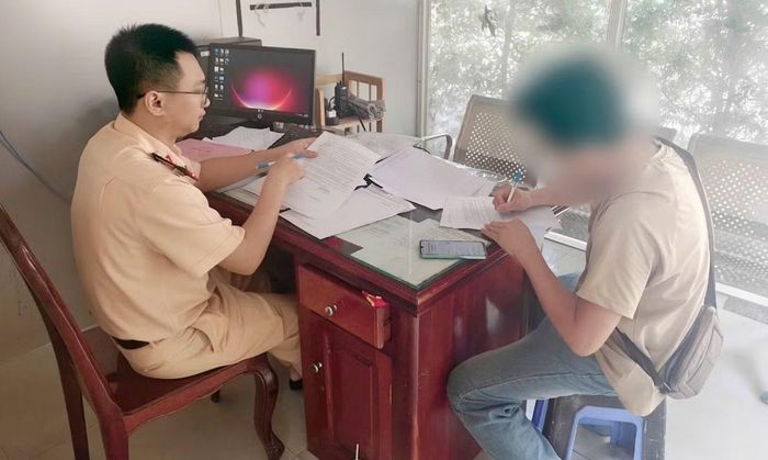 Tài xế N.T.H. làm việc với cơ quan CSGT về hình ảnh vi phạm do camera giám sát ghi lại. (Ảnh: Công an TP. Đồng Nai)