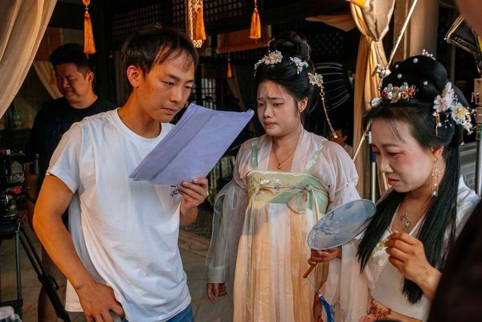 Đạo diễn trẻ hướng dẫn khách du lịch trước một cảnh quay.