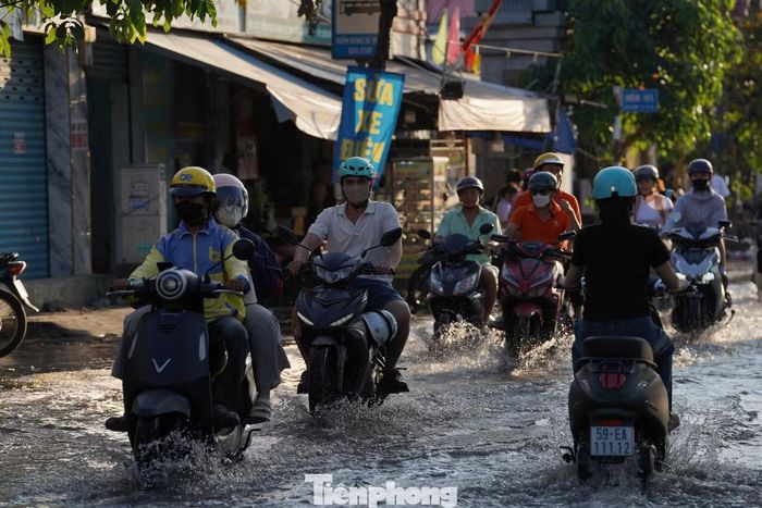 Các phương tiện di chuyển chậm qua khu vực bị ngập, người điều khiển xe máy phải cẩn thận tránh những đoạn nước sâu.