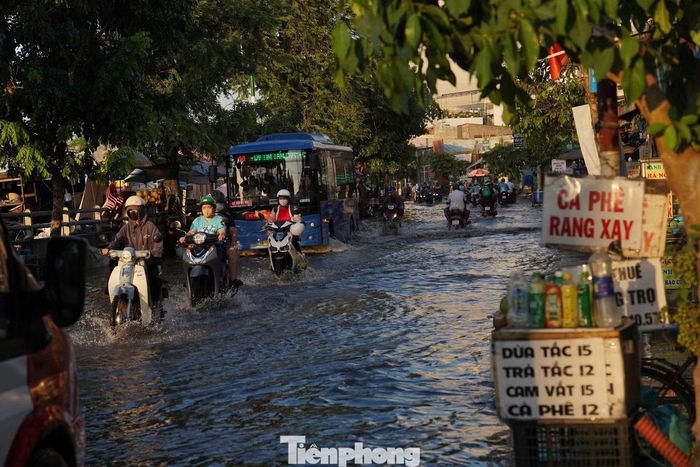 Nước tràn vào các cửa hàng, ảnh hưởng đến hoạt động kinh doanh của người dân ven đường.