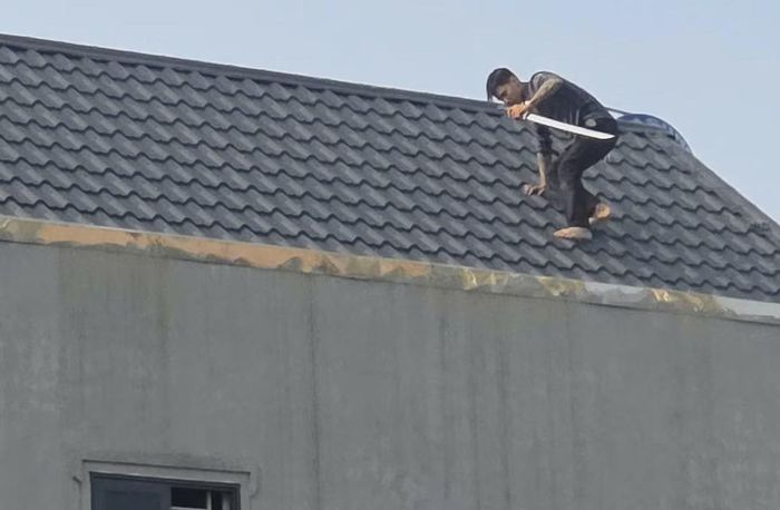 Theo người dân địa phương, từ chiều 26/10, 2 đối tượng đã leo lên mái nhà, cầm kiếm cố thủ, không xuống dù lực lượng chức năng phát loa cảnh báo.