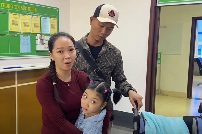 Vợ chồng anh Long kiên trì mỗi ngày đưa con đến bệnh viện tập vật lý trị liệu. Ảnh: GĐCC.
