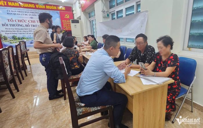 Cán bộ Ban Quản lý dự án đầu tư - hạ tầng phường Bạch Mai làm thủ tục chi trả tiền bồi thường, hỗ trợ giải phóng mặt bằng cho người dân. Ảnh: Thành Huế