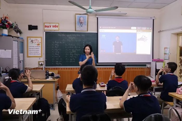 Giáo viên sử dụng ngôn ngữ ký hiệu kết hợp với giáo cụ trực quan trong giờ học. (Ảnh: Thùy Trang/Vietnam+)