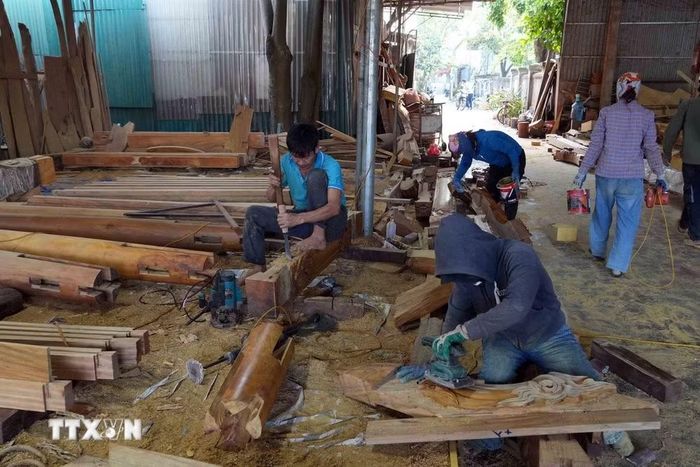 Cơ sở mộc chuyên chế tác nhà thờ gỗ mít của ông Nguyễn Đức Minh tạo việc làm ổn định cho lao động địa phương. (Ảnh: Hữu Quyết/TTXVN)