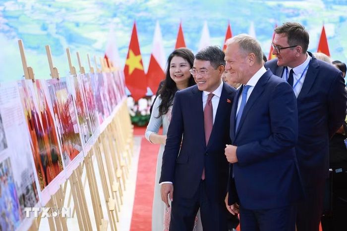Thủ tướng Lê Minh Hưng và Thủ tướng Cộng hòa Ba Lan Donald Tusk tham quan trưng bày ảnh về quan hệ hợp tác giữa hai nước do Thông tấn xã Việt Nam thực hiện. (Ảnh: Dương Giang/TTXVN)